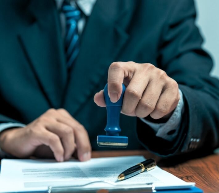 Official pressing a stamp onto a document at a desk, illustrating the 2022 UAE new visa rules