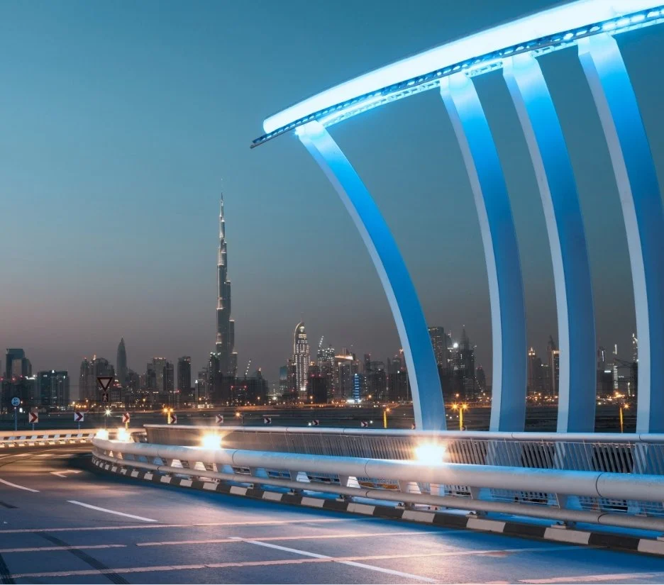 Illuminated Dubai Water Canal bridge with the city skyline behind, illustrating Meydan Free Zone