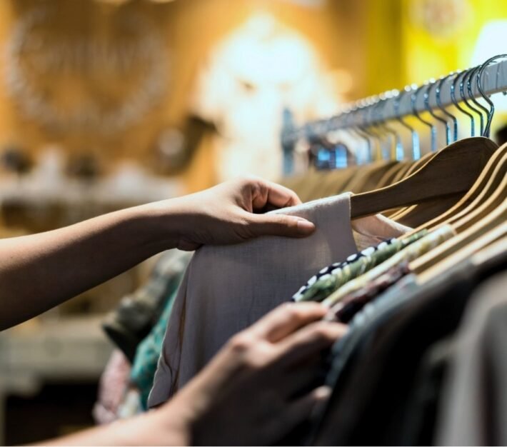 Shopper browsing clothing on a rail in a boutique, illustrating the UAE pre-loved fashion market