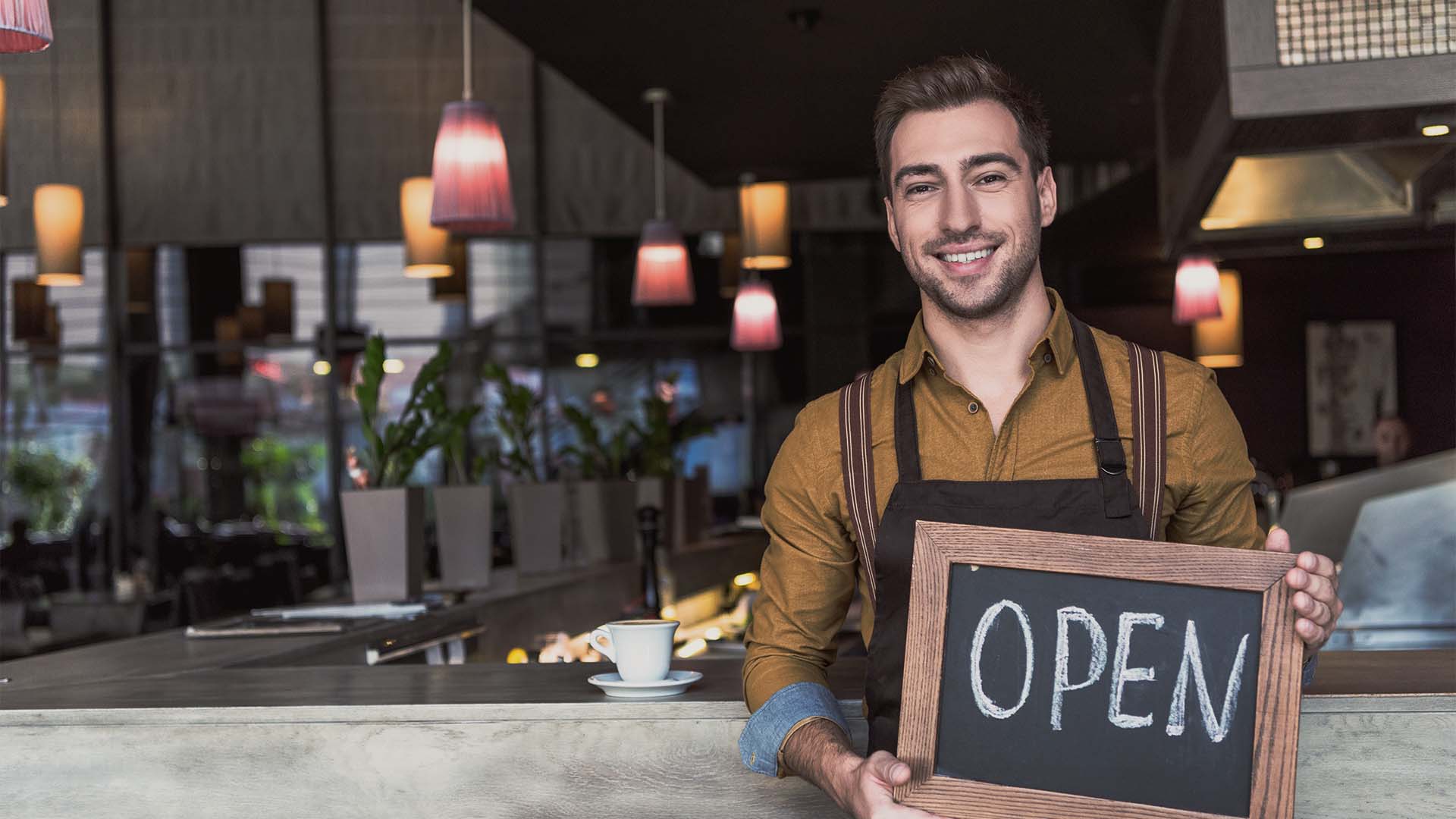 Man holding open sign of restaurant