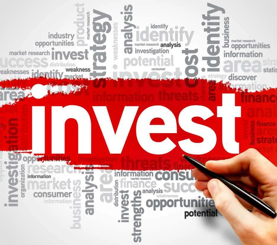 Hand pointing at a word cloud centred on the word invest, illustrating key industries to invest in Dubai